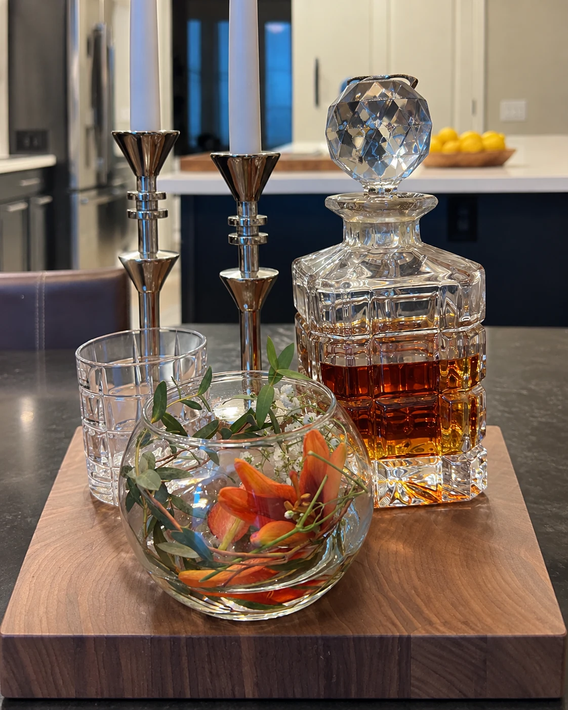Faceted decanter and floral glass displayed on a handcrafted wood board