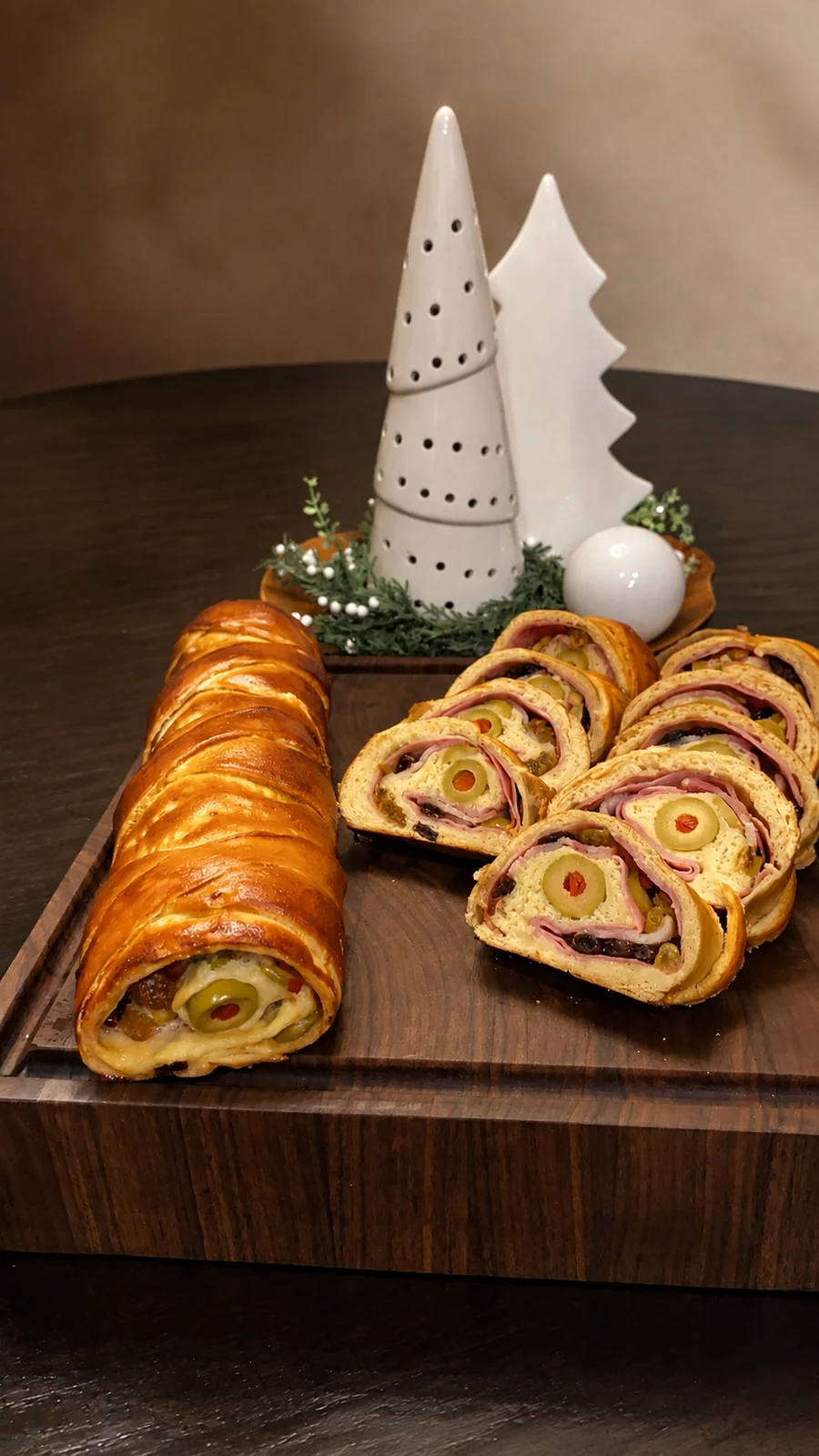 Walnut serving board arranged with a sliced holiday pastry