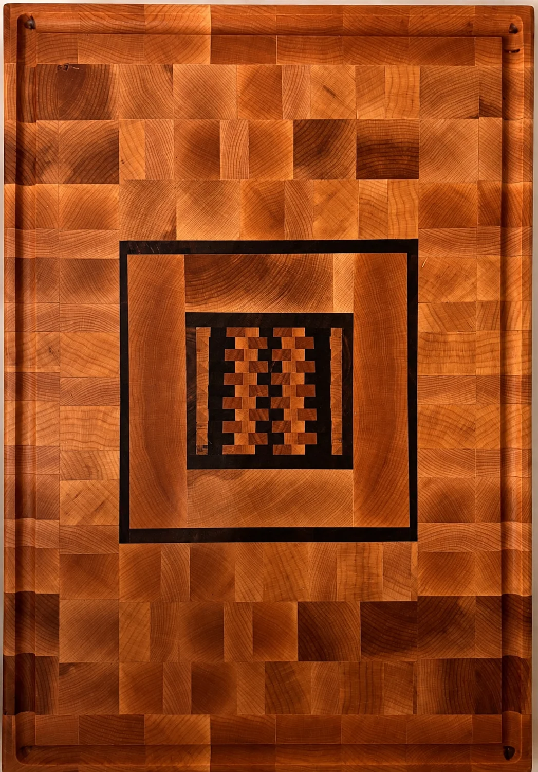 End-grain board with a woven geometric center and dark inlay