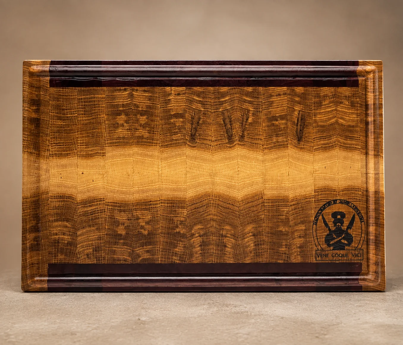 Figured oak cutting board with dark edging, juice groove, and maker's mark