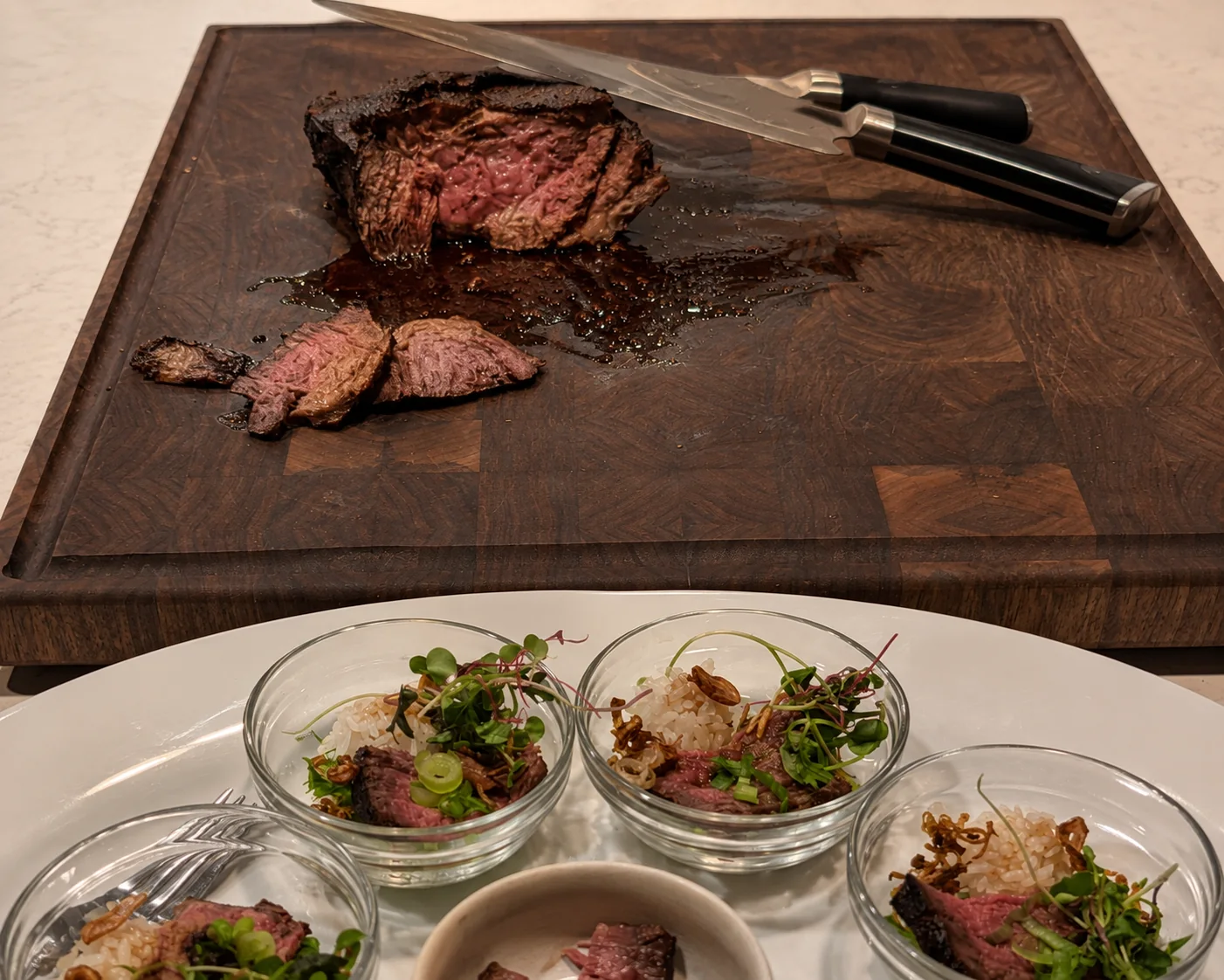 Dark walnut end-grain cutting board in use for preparing and serving sliced steak
