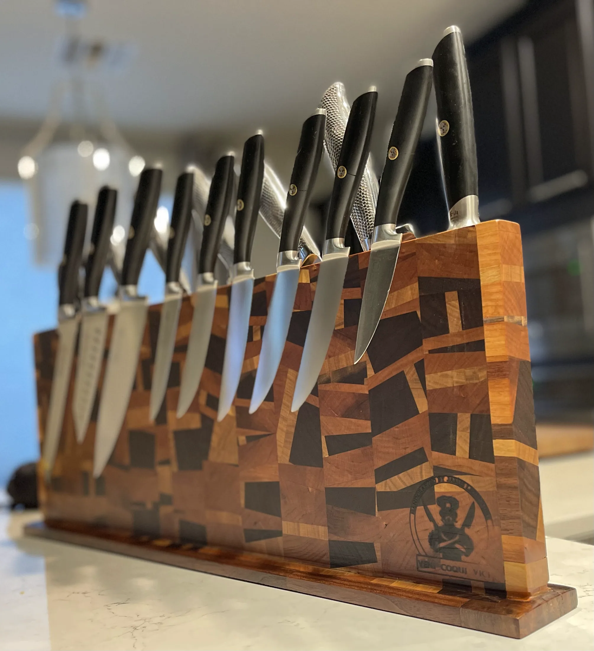Chef knives displayed on patterned magnetic wooden holders